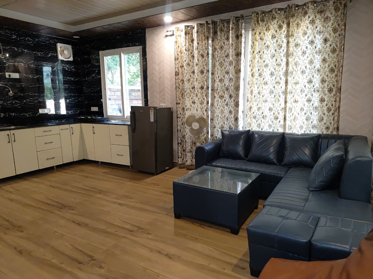 Living room with leather sofa and modular kitchen
